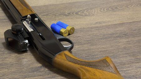 shotgun with bullets on wooden background