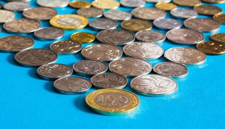Tenge on a blue background with coins. Tenge coins of Kazakhstanの写真素材