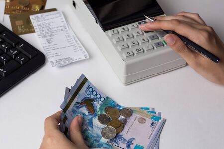 Tenge at the cashier accountant in the hands of the workplace in the office. The cashier counts the money KZT in the workplace in Kazakhstan. Salary in Kazakhstanの写真素材