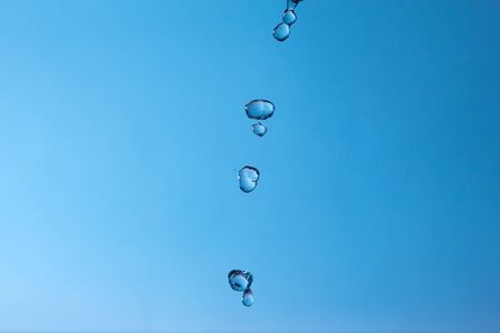 Falling water drops on a blue background.
