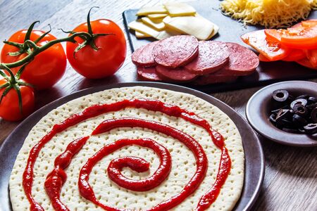 Cooking pizza at home. Ingredients for cooking pizza are on a wooden table.の写真素材