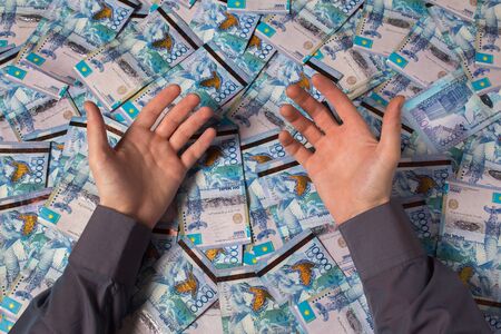 Hands are on a table full of Kazakhstan tenge money. Paper banknotes tenge KZT. Tenge is the national currency of Kazakhstan. bank of Kazakhstanの写真素材