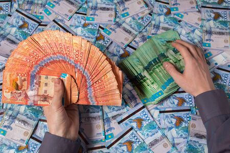 Hands holding Kazakhstani tenge money. Paper banknotes tenge KZT. Tenge is the national currency of...