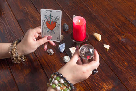 Bangkok, Thailand, March.15.20.A fortune teller holds a magic ball and a Tarot card with a heart.The Gypsy lays out Tarot cards and guesses for the future.Magical sessions with the cards.Clairvoyanceのeditorial素材