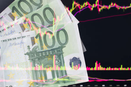 euro, EUR in front of a laptop monitor with a price chart.Forex and trading.A trader trades stocks,bonds and securities or currencies on the Forex market or stock exchange for euroのeditorial素材