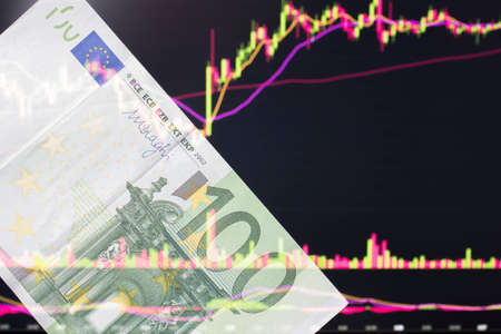 euro, EUR in front of a laptop monitor with a price chart.Forex and trading.A trader trades stocks,bonds and securities or currencies on the Forex market or stock exchange for euroのeditorial素材