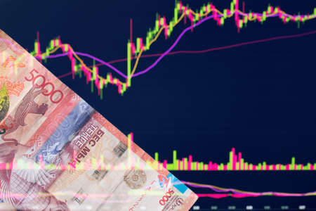 Tenge in Kazakhstan against the background of a laptop with an open chart of the currency market or...