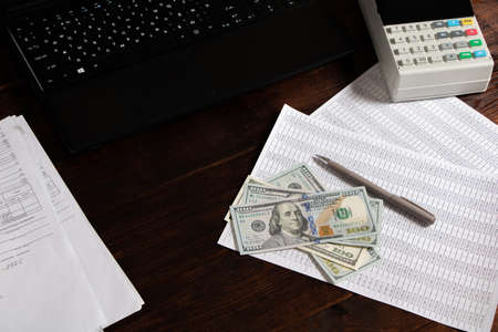 Work in the office with finances, documents, invoices and mortgages. Money dollars are on documents, accounts or mortgages in the office on the tableのeditorial素材