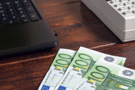 Money Euro are on documents, accounts or mortgages in the office on the table. Work in the office with finances, documents, invoices,mortgages or pay salaryのeditorial素材