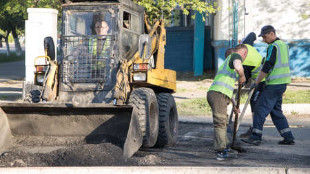 Moscow, Russia-07.05.2020: Road works. Workers repair the road surface and asphalt the street....