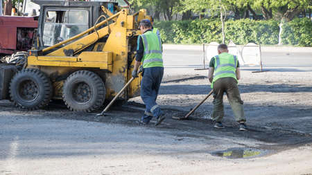 Moscow, Russia-07.05.2020: Road works. Workers repair the road surface and asphalt the street....
