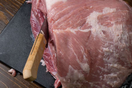 Slice the pork or beef with a knife on the table in close-up.Preparation of meat dishes and food products.Pieces of red meat for shish kebab, barbecue or kebab.Raw fresh meat is cut with a knife.recipeの写真素材