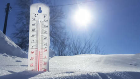 Thermometer in winter in the cold on snow and analyzes low negative air temperatures in clear sunny...