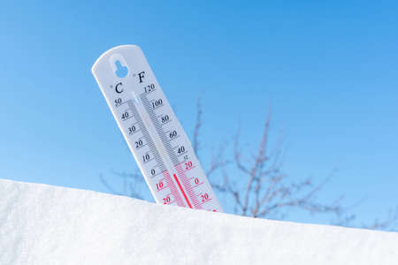 The thermometer in winter lies on the snow and shows low negative air temperature. Meteorological...