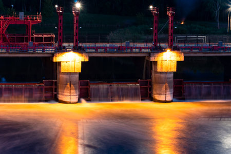 River,dam,bridge in the evening.Car and pedestrian bridge at night. A full-flowing river with a strong current.Clean,bubbling,fresh water.Technical construction on the river, fresh water reserves.の写真素材