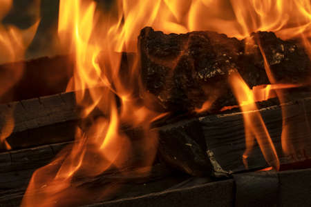 A blazing fire in the dark. Ignition of wood in the fire. A bright burning flame. Sparks and flames...