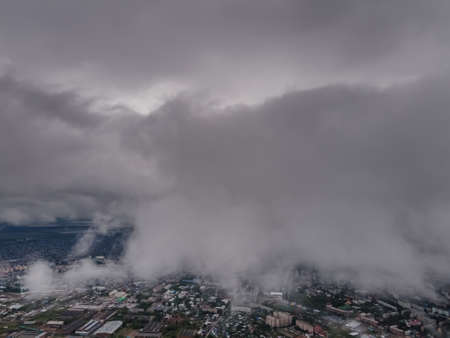 Flying through thick clouds. Rain clouds in the sky. Cumulus clouds, meteorology and climate studies.Photo of the city from the height of clouds, aerial photography.Quadcopter,droneの写真素材