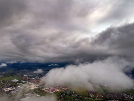 Flying through thick clouds. Rain clouds in the sky. Cumulus clouds, meteorology and climate studies.Photo of the city from the height of clouds, aerial photography.Quadcopter,droneの写真素材