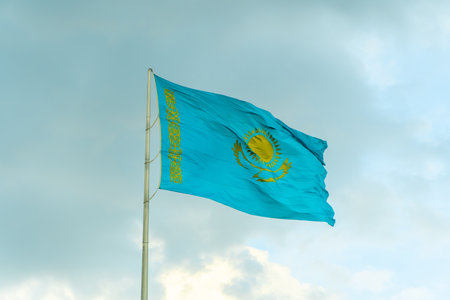 Flag of Kazakhstan on sky background. Waving flag of Republic of Kazakhstan. Fabric textures flowing flag of Kazakhstan.の写真素材