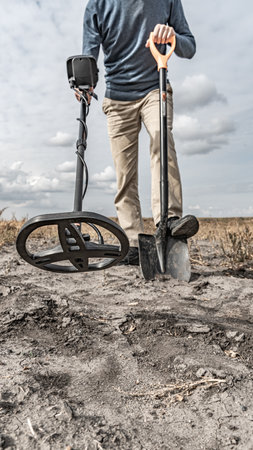 Archaeological and treasure hunting with a metal detector.Hunting for relics in the ground.Search for antiques.Soil research on gold nuggets.A man with a metal detector and a shoveの写真素材