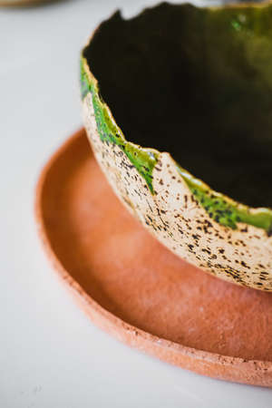 A product made of clay. Colorful kitchen items on the shelf. Handmade plateの写真素材