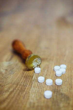 Vintage wax seal stamp lies on a wooden table. Golden spoon and pieces of waxの写真素材