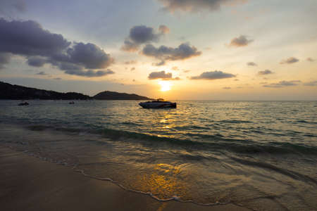 Phuket, Thailand - March 06, 2020: Sunrise on the tropical beach. There is a boat at seaのeditorial素材