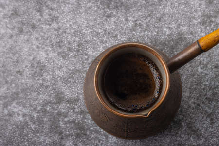 Top view of vintage cezve with brewed coffee on gray backgroundの写真素材