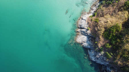 Aerial view. Top view of turquoise sea water washes the rocky shore in Thailand. Landscape backgroundの写真素材