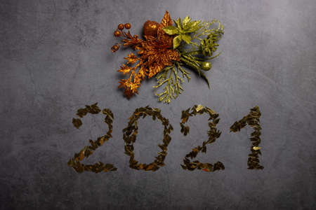 2021 New Year composition. Green and orange decorations in the form of flowers and Christmas balls...