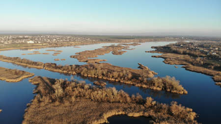 The estuary of a river with blue water. On the bank and in the middle of the river there are dry...
