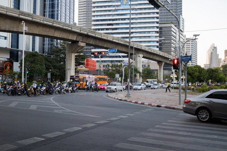 Bangkok, Thailand - March 26, 2020: Scooters, motorcycles, cars and buses stand at the crossroads...