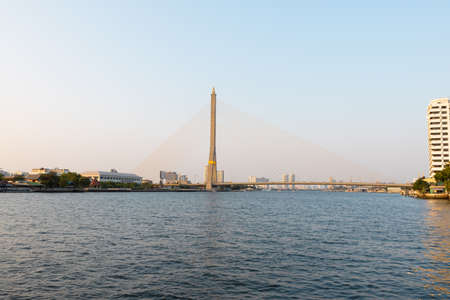 View of the river Chao Phraya and the bridge over the river under which the local river passengers transport floats. Bangkok, Thailandの写真素材