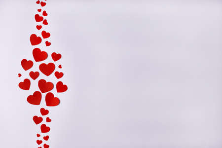Pattern of red hearts on the left side on a white background. Valentines Day, February 14, love concept. Copy spaceの写真素材
