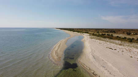 Aerial view of sandy beach and Black sea. Coastline with green bushes and grass. Dzharylhach island,...