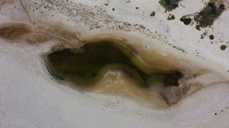 Aerial top view of small shallow lake among white sand on Dzharylhach island. Ukraineの写真素材
