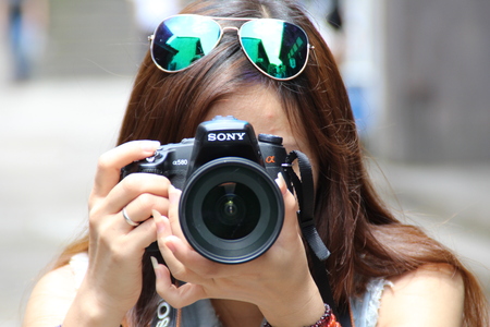 Woman holding camera taking picturesのeditorial素材