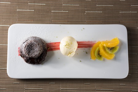 Soft chocolate with vanilla ice cream and fresh fruitの写真素材