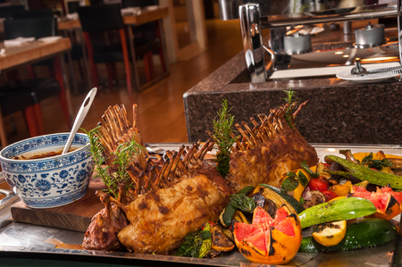 Grilled Rack of lamb with fruits and vegetables on a cutting boardの写真素材