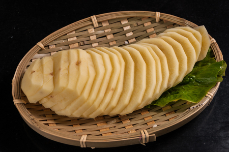 sliced potatoes in the bamboo basketの写真素材