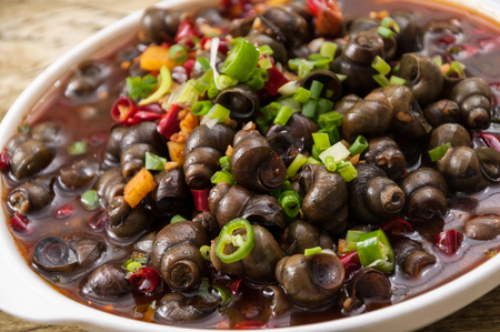 field snail stir fried with chili sauce, a popular chinese dishの写真素材