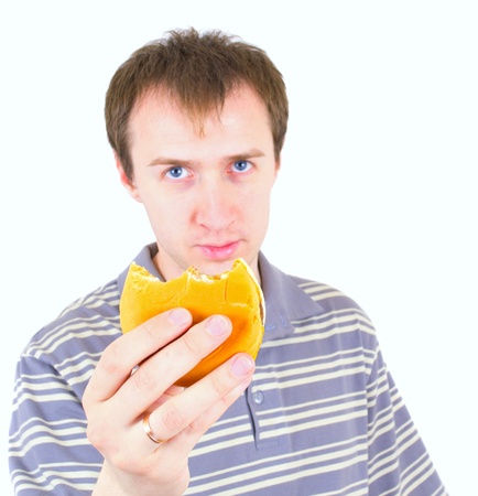The young man eats a hamburger. Focus on hamburger.の写真素材