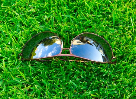 Sun glasses on a green grassの写真素材
