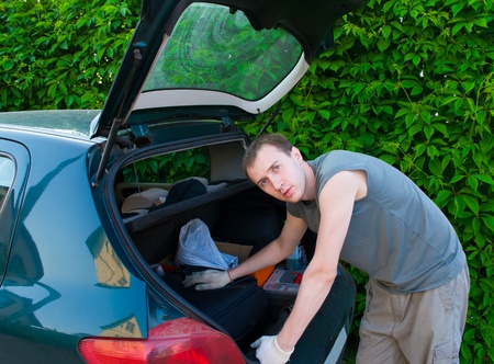 The man searches for something in a carの写真素材