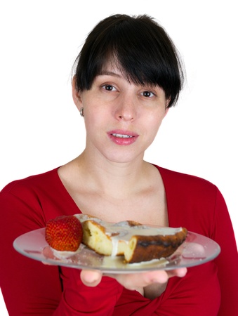The young girl offers a pie with a strawberry on a plateの写真素材