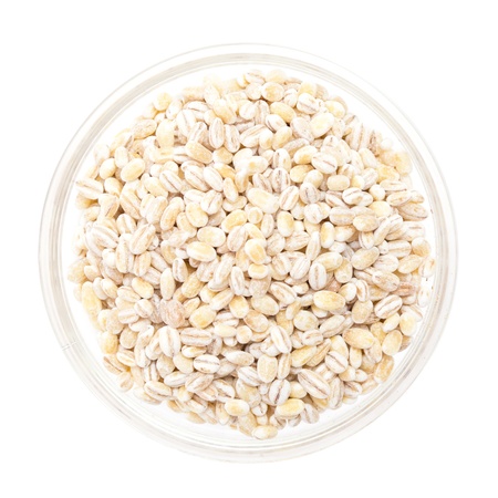 pearl barley in a glass bowl isolated on whiteの写真素材
