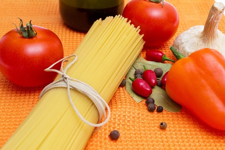 Raw spaghetti and few fresh tomatoes, pepper, egg, garlicの写真素材