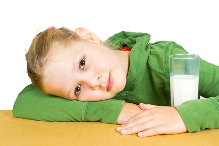 Cute little girl with a glass of milk, isolated over whiteの写真素材