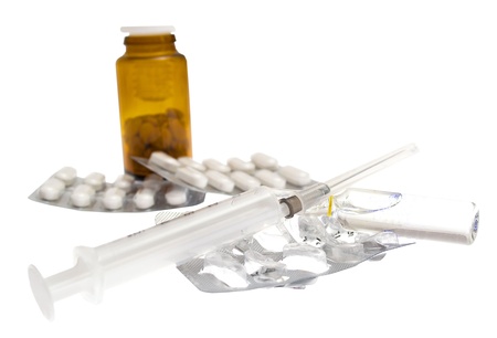 pills and a syringe on a white backgroundの写真素材