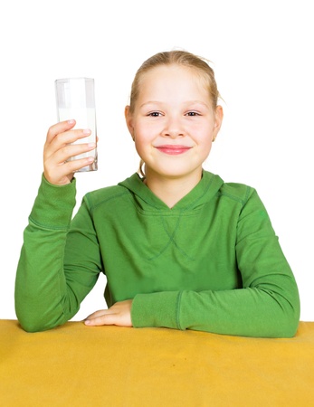 Happy little girl with a glass of milk, isolated over whiteの写真素材